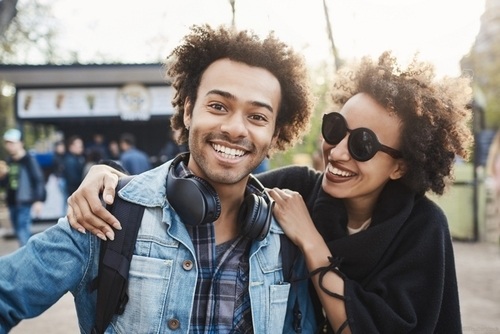 A couple smiling standing together in a park