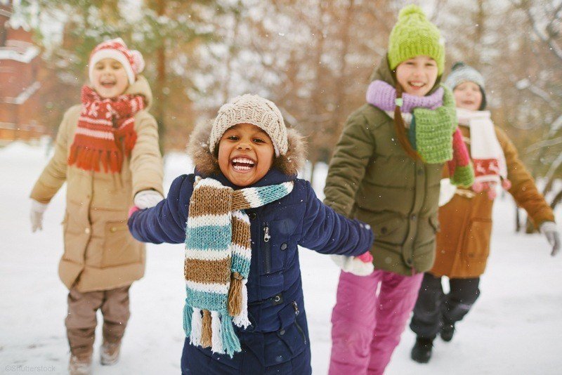 Children holding hands in the snow.